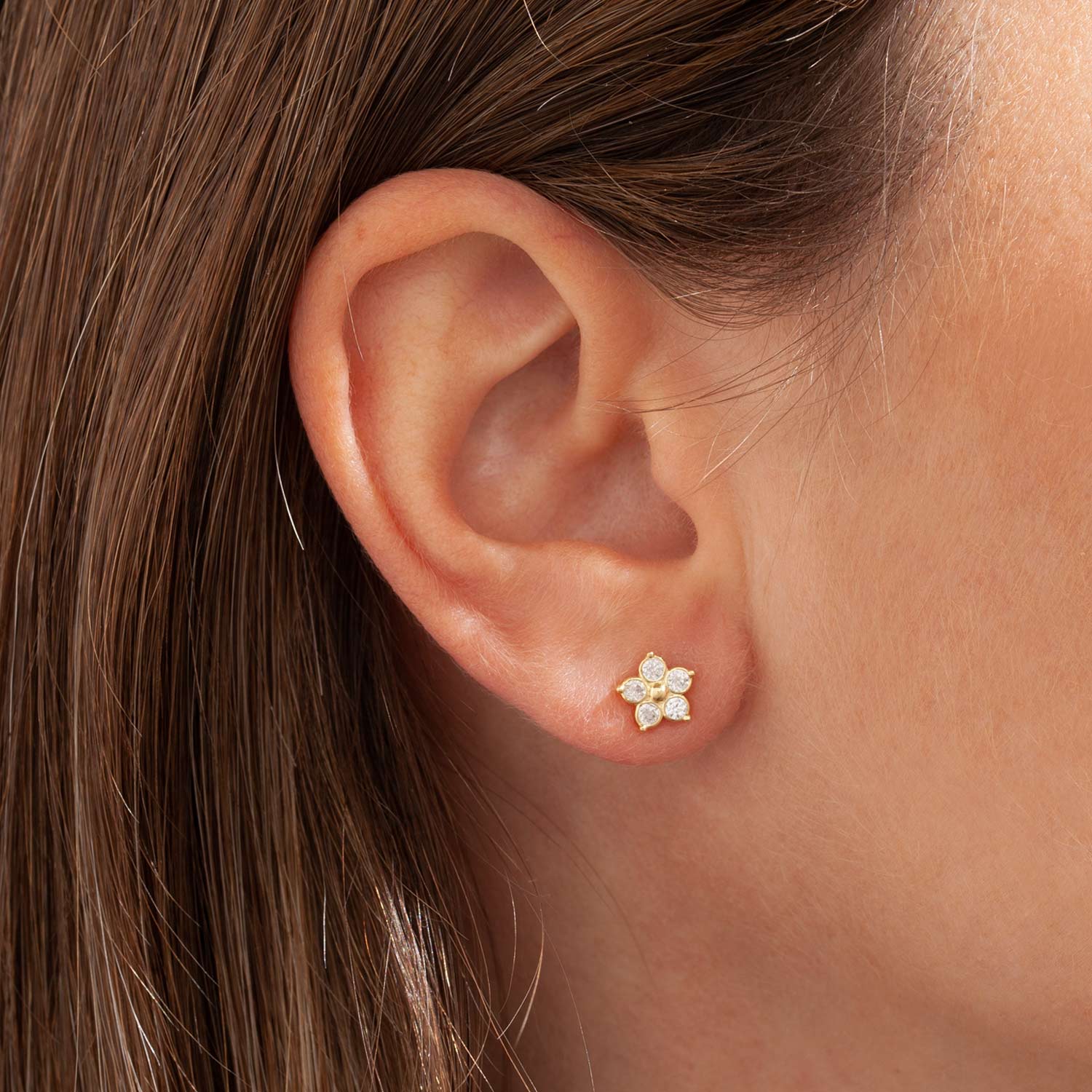 Orecchino mini margherita a lobo. Zirconi bianchi che formano i petali con pallino centrale. Personalizzabile in diversi colori.