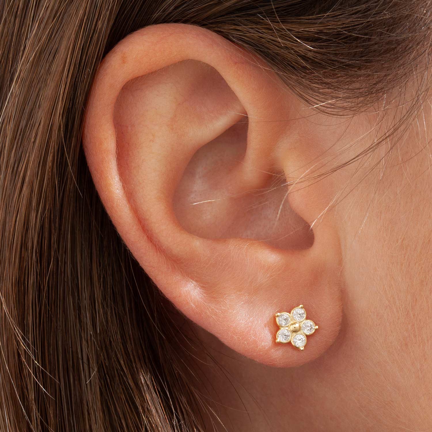 Orecchino Margherita Fiore piccolo a lobo. Placcato oro. Fiorellino delicato a forma di margherita. Pallino centrale con zirconi incastonati che formano i petali.