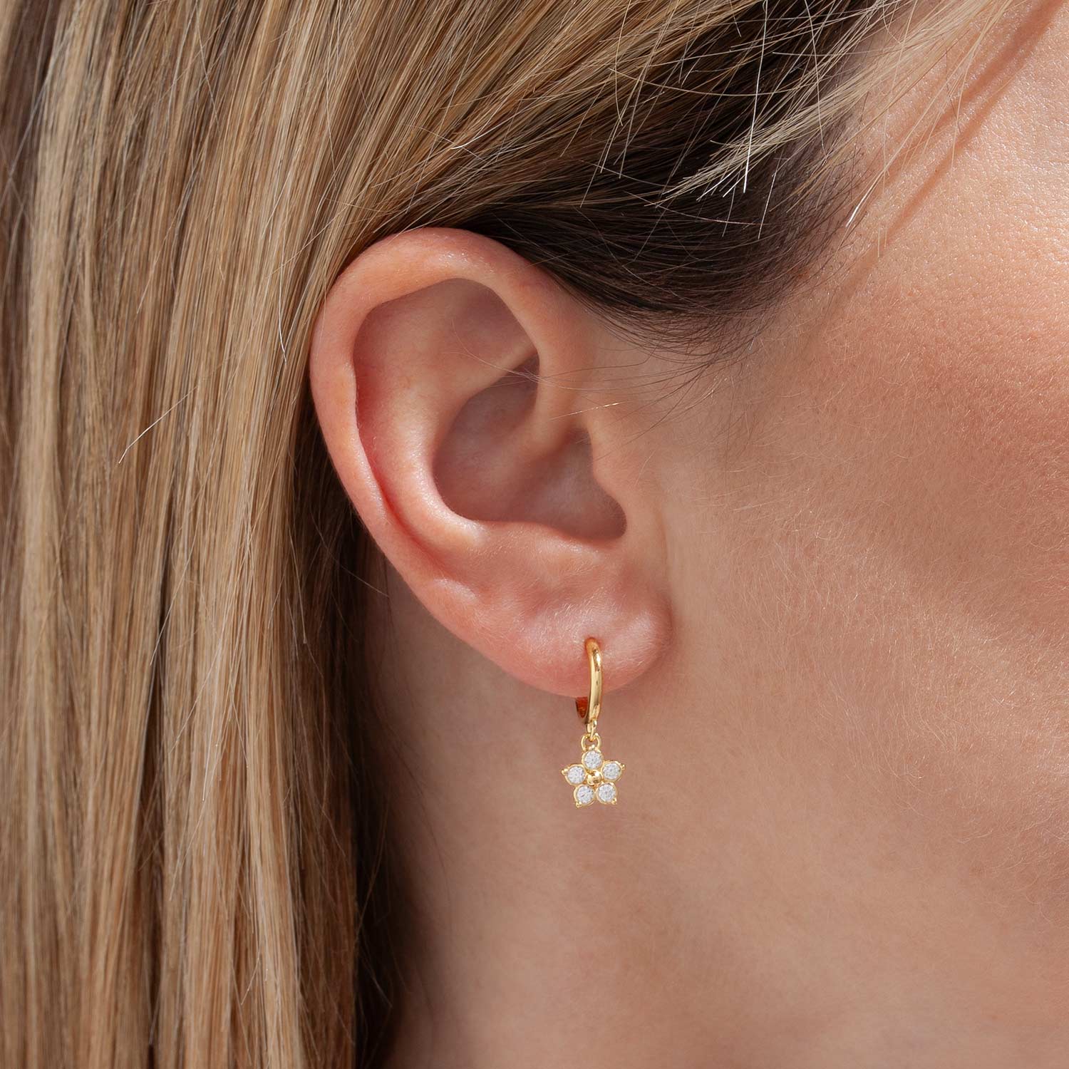 Orecchino con cerchietto e fiorellino pendente. Margherita pendete con zirconi brillanti. Cerchietto liscio con micro margherita pendente.