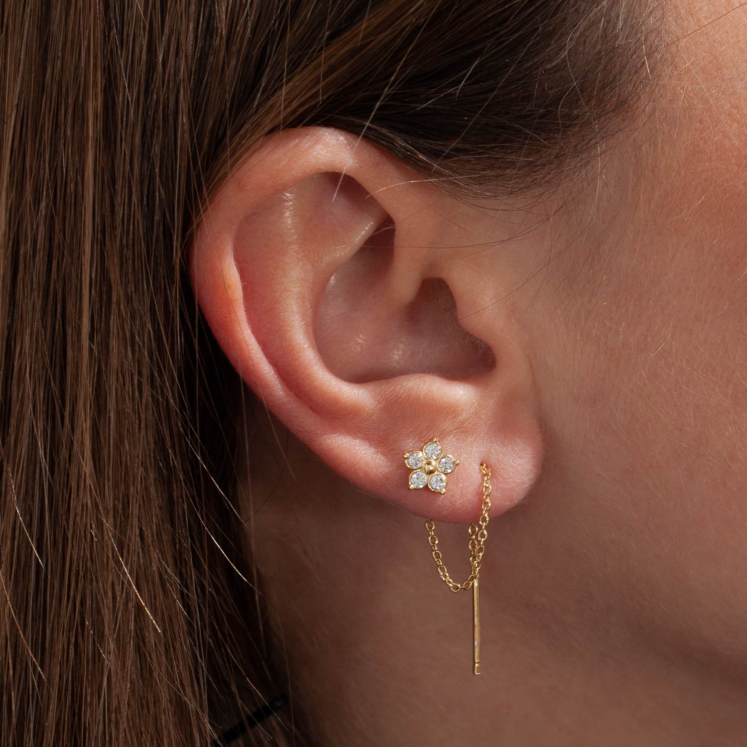 Fiore con catenina modello threader. Orecchino in argento 925 e zirconi incastonati. Catenina pendente che può essere indossata su più fori a lobo. Gioiello realizzato in Italia.